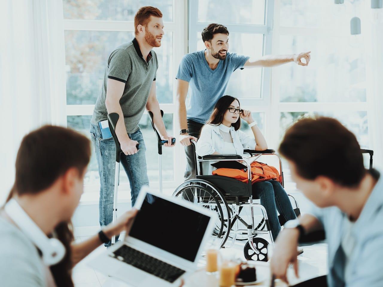 This image shows a woman in a wheelchair being pushed by a staff.