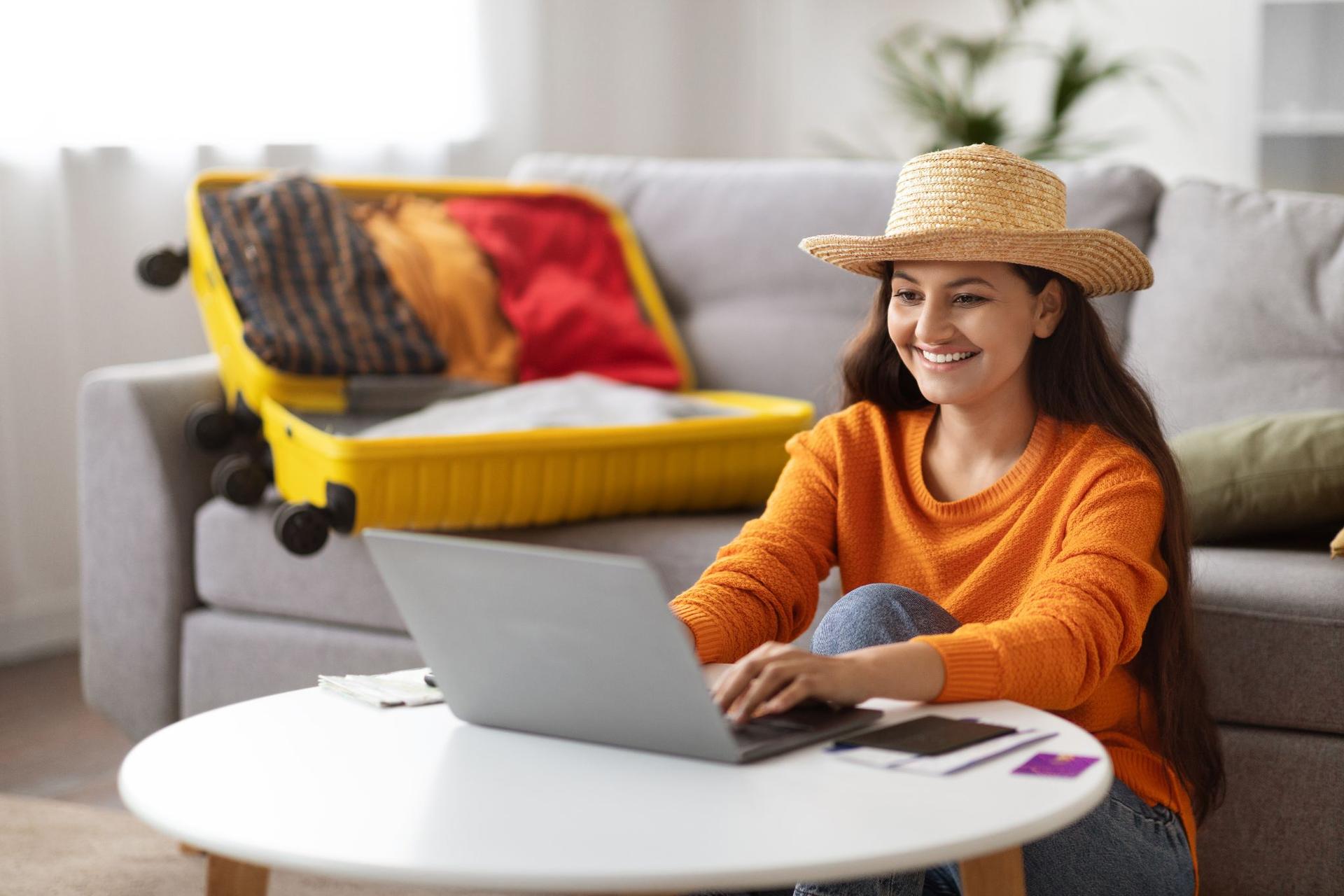 A woman checking the information on the destination on the computer and preparing for travel.