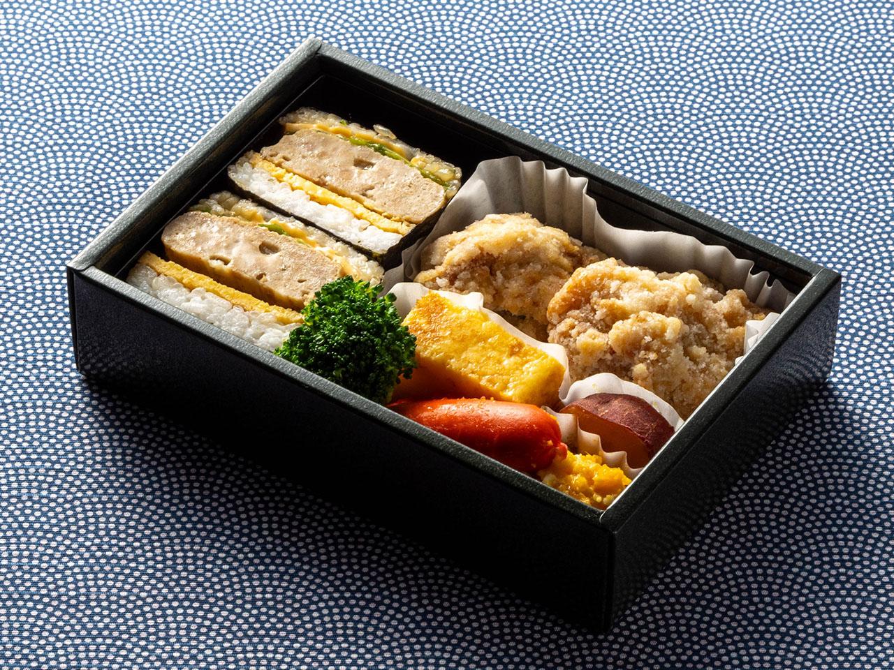 "นี่คือรูปภาพอาหารบนเครื่อง ข้าวกล่องโอมูซูบิเบ็นโต"